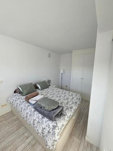马德里Cómodo apartamento en Madrid的白色卧室配有带床单和枕头的大床