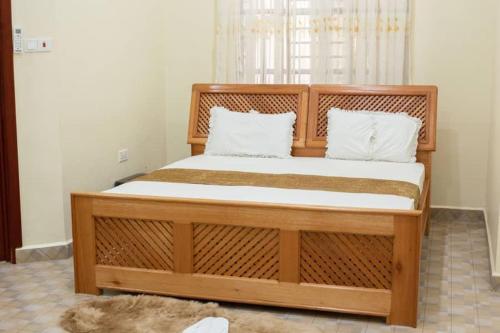 莫希Hellen's Riverside villas的卧室内的一张带两个枕头的木床