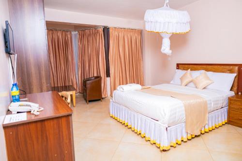 ThikaPaleo Hotel and Spa的一间卧室配有一张床和一张书桌及电话