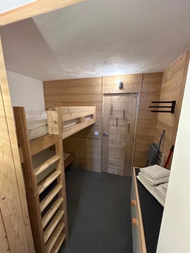 圣莫里斯堡Appartement Cosy Les arcs 1800的客房设有双层床和衣柜。
