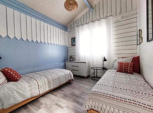 塔布La Caravelle - Chalet t2 climatisé lit queen size ou twin的一间卧室设有两张床和窗户。