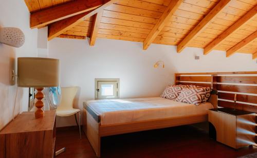 阿约斯尼奇塔斯Villa Dioni的一间带一张床的卧室,位于带木制天花板的房间内
