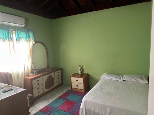 圣玛丽Seaview Villa的一间卧室配有一张床、梳妆台和镜子