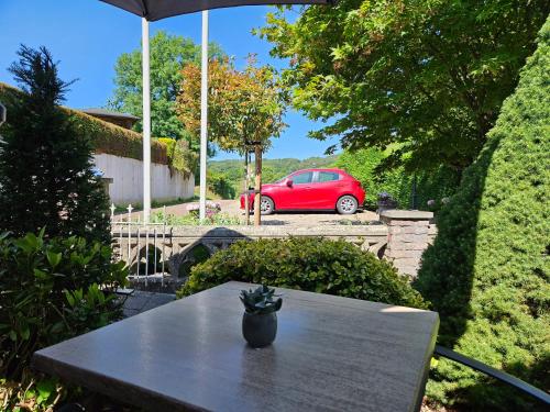 梅赫伦Appartementen Vouwere的一张桌子,一辆红色的汽车停在院子里