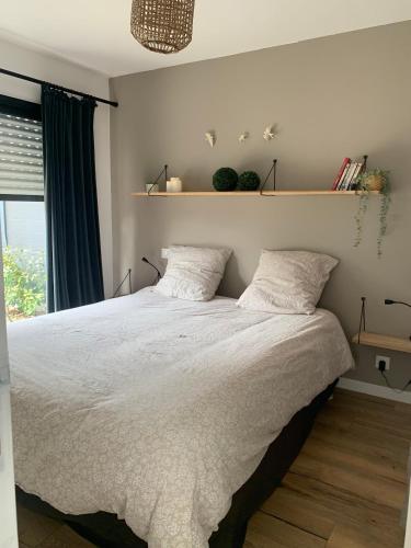 Beaussais sur MerLE REFUGE DE LA BAIE的卧室配有一张带两个枕头的大白色床