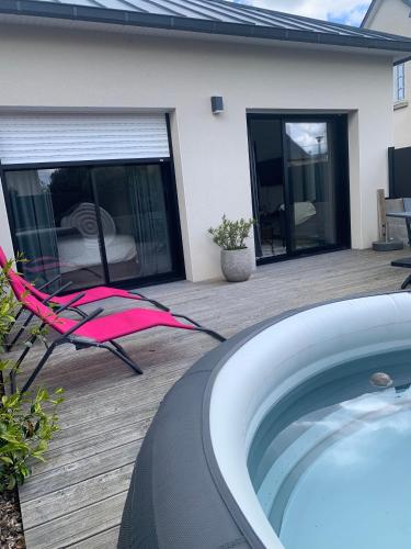 Beaussais sur MerLE REFUGE DE LA BAIE的房屋旁设有带热水浴池和椅子的天井。