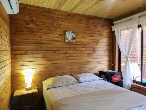 别霍港TortugaBay的一间卧室设有一张床和木墙