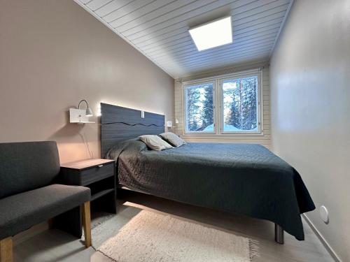 鲁卡Villa Kiviaapa in Ruka Kuusamo的一间卧室设有一张床、一个窗口和一把椅子