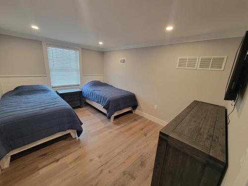 Brighton Beach6 Bedroom Luxury Home的一间卧室设有两张床,铺有木地板