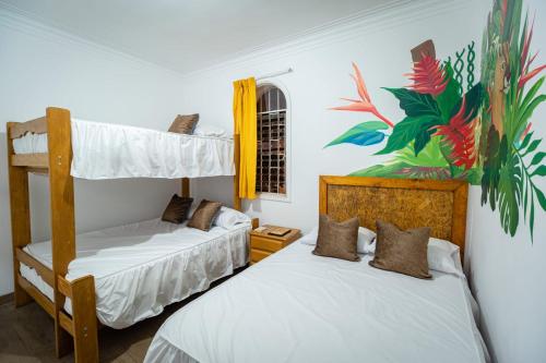 利马Casa Águila y Cóndor的卧室配有两张双层床,墙上挂有绘画作品