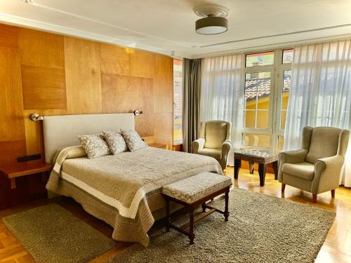 阿里纳斯·德·卡伯瑞勒斯Hotel La Rivera的一间卧室配有一张床和两把椅子