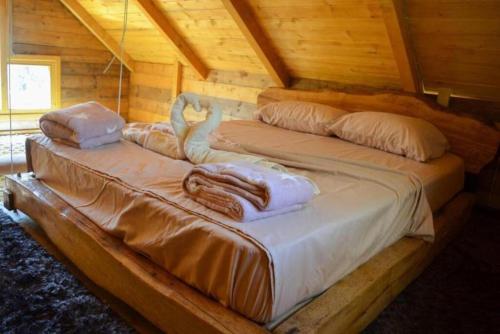 乌尔齐尼Mavric Cabin的小木屋内的两张床,配有毛巾