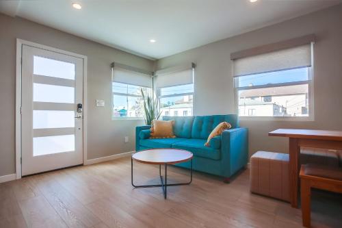 圣地亚哥Ocean Beach Retreat, 3BR Newly Remodeled, Steps to Beach and Boardwalk的客厅配有蓝色的沙发和桌子