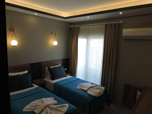 ErdemliBasar hotel的一间卧室配有两张带毛巾的床