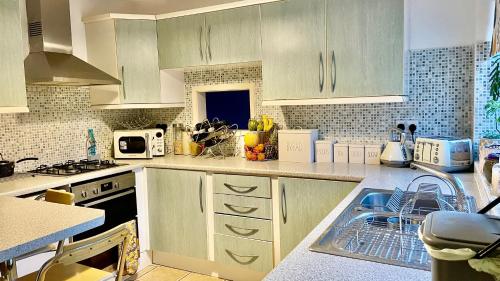 彼得伯勒Magnolia的厨房配有白色橱柜和水槽