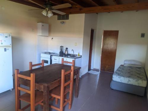 瓜莱瓜伊Bungalows Gualeguay的厨房配有桌子、水槽和冰箱