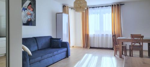 克拉科夫Miriam Apartment Kraków Borkowska的客厅配有蓝色的沙发和桌子
