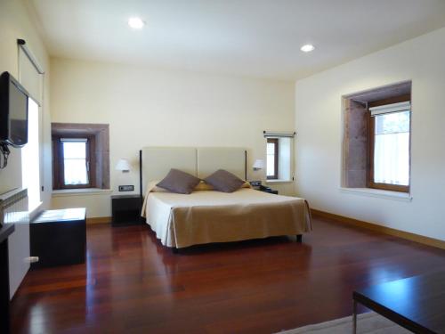 Maya del BaztánHotel Jauregi Borda的铺有木地板的客房内设有一间卧室和一张床。