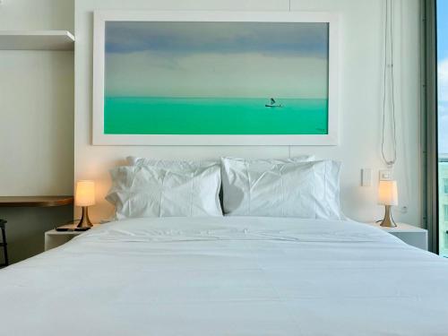 卡塔赫纳Wonderful 2BR with impressive view的卧室配有白色床,上面有绘画作品