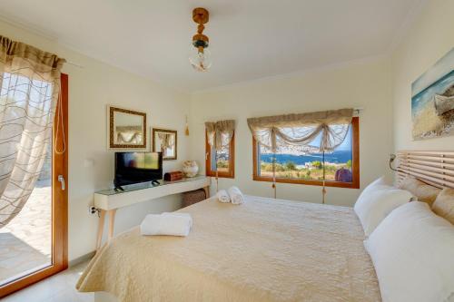 埃尔莫波利斯Villa Marenosta的一间卧室配有一张大床和电视