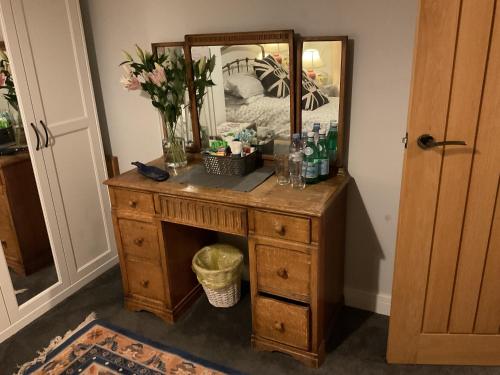 BredonPrivate Room in a house in the Cotswolds的梳妆台,上面装有镜子和鲜花