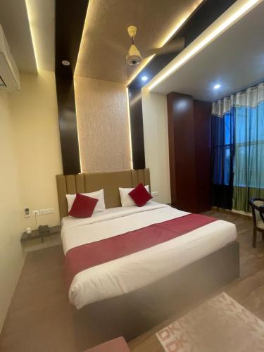 马图拉Hotel City Star Family Stay的一间卧室配有一张带红色枕头的大床