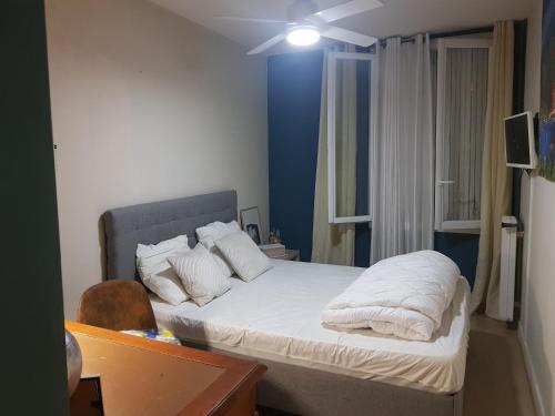 尼姆Chambre spacieuse dressing WC et SDB communes的一间卧室配有带白色床单和枕头的床。