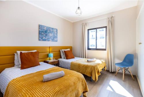 阿尔布费拉Vista Mar e Terra的一间卧室配有两张床和一张蓝色椅子