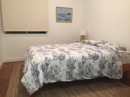 帽头镇Creekside at Hat Head - 7 Creek Street的一间卧室配有一张带蓝色和白色床单的床。