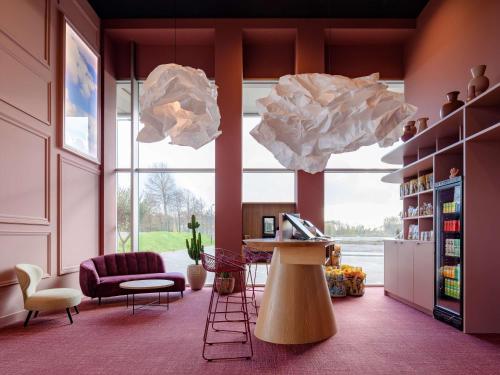 鹿特丹ibis Styles Rotterdam Ahoy的客厅设有桌子和大窗户