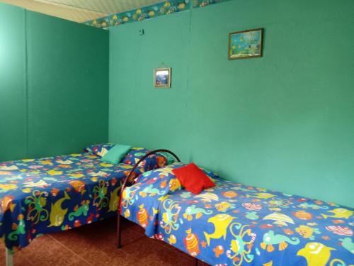 埃尔巴列德安通Villa la paz的一间卧室设有两张床,拥有蓝色的墙壁。