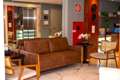 尤西德福拉Nobile Hotel Juiz de Fora的客厅配有棕色的沙发和椅子