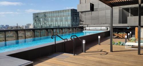 墨尔本Centrally Located Modern Loft w Free Parking, Infinity Pool, Workspace的建筑物屋顶上的游泳池