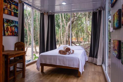 艾库玛尔Jungle house with a pool的一间卧室设有一张床和一个大窗户
