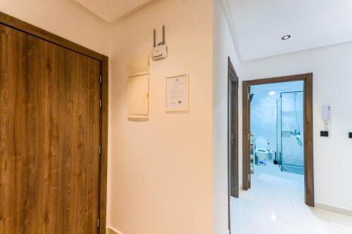 纳祖尔Résidences & Suites Nador的走廊设有木门和浴室