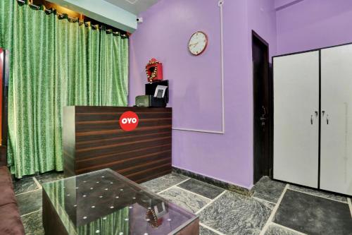 勒克瑙Collection O Hotel RBS的一间紫色墙壁的房间和墙上的时钟