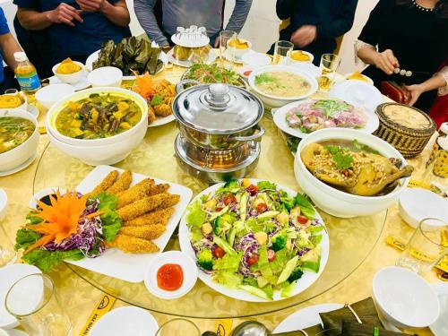 Anh SơnKHÁCH SẠN KIM NHAN的餐桌上放着食物和碗