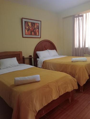 齐克拉约Hotel San Eduardo的两张位于酒店客房的床,配有毛巾