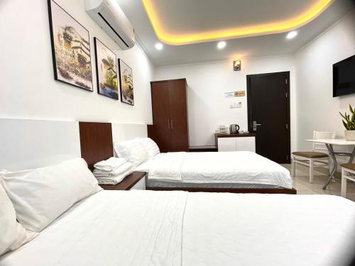潘郎KAMI HOTEL的酒店客房设有两张床和一张桌子。