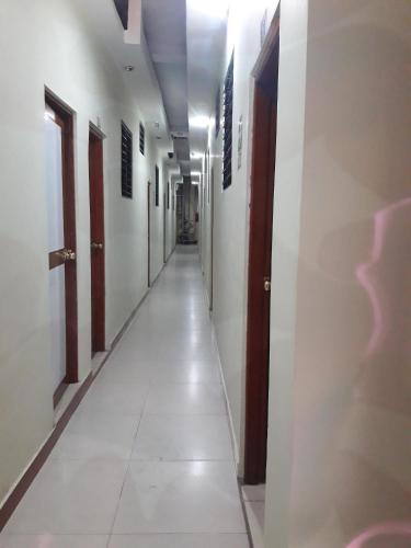 伊基托斯Hostal Real Center的一条空的走廊,有白色的墙壁和长长的过道