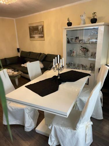 科隆Ferienwohnung的一间设有白色桌子和白色椅子的用餐室