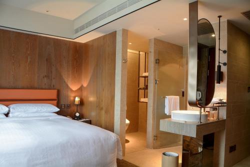 台东台东桂田喜来登酒店的一间卧室设有一张大床和一个水槽