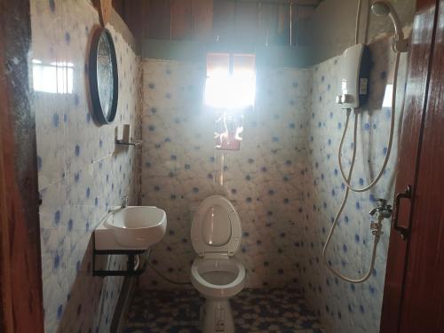 Phumĭ PôyBanlung Hill Top House &Trekking的浴室配有卫生间、水槽和灯