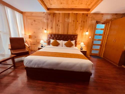 马拉里Vista Resort, Manali - centrally Heated & Air cooled luxury rooms的一间卧室配有一张大床和一把椅子