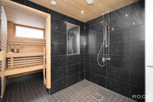 埃斯波Cozy Holiday Home with Outside Jacuzzi的浴室设有黑色瓷砖淋浴。