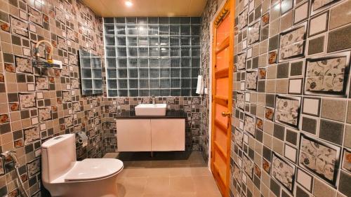 马拉里Vista Resort, Manali - centrally Heated & Air cooled luxury rooms的一间带卫生间和瓷砖墙的浴室