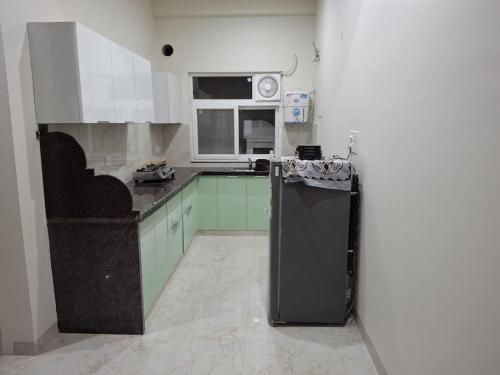 斋浦尔636 Kedia Kothhi的厨房配有黑色冰箱和微波炉。