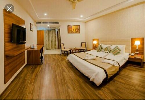 瓦拉纳西Hotel New Ashiyana Palace Varanasi - Fully-Air-Conditioned hotel at prime location With Wifi , Near-Kashi-Vishwanath-Temple, and-Ganga-ghat - Best Hotel in Varanasi的酒店客房设有一张大床和一张书桌。
