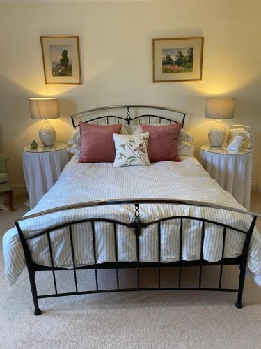 比明斯特Lower Farm Cottage的一间卧室配有一张大床和枕头