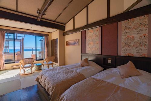 河津町Isoaruki no Yuyado Ushiogumo -6 years or older-的一间卧室配有一张床,享有海景